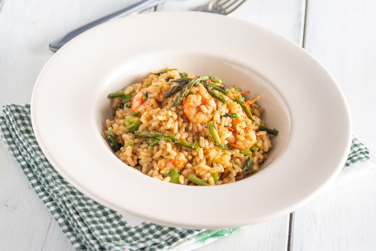 Weight Watchers Shrimp Risotto with Asparagus Recipe in a wide brimmed, white bowl on a cloth napkin.