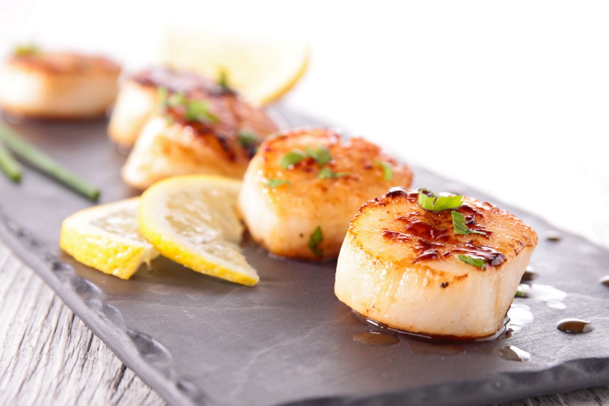 Weight Watchers Truffle Salt Seared Sea Scallops on a dark, rectangular plate with a white background.