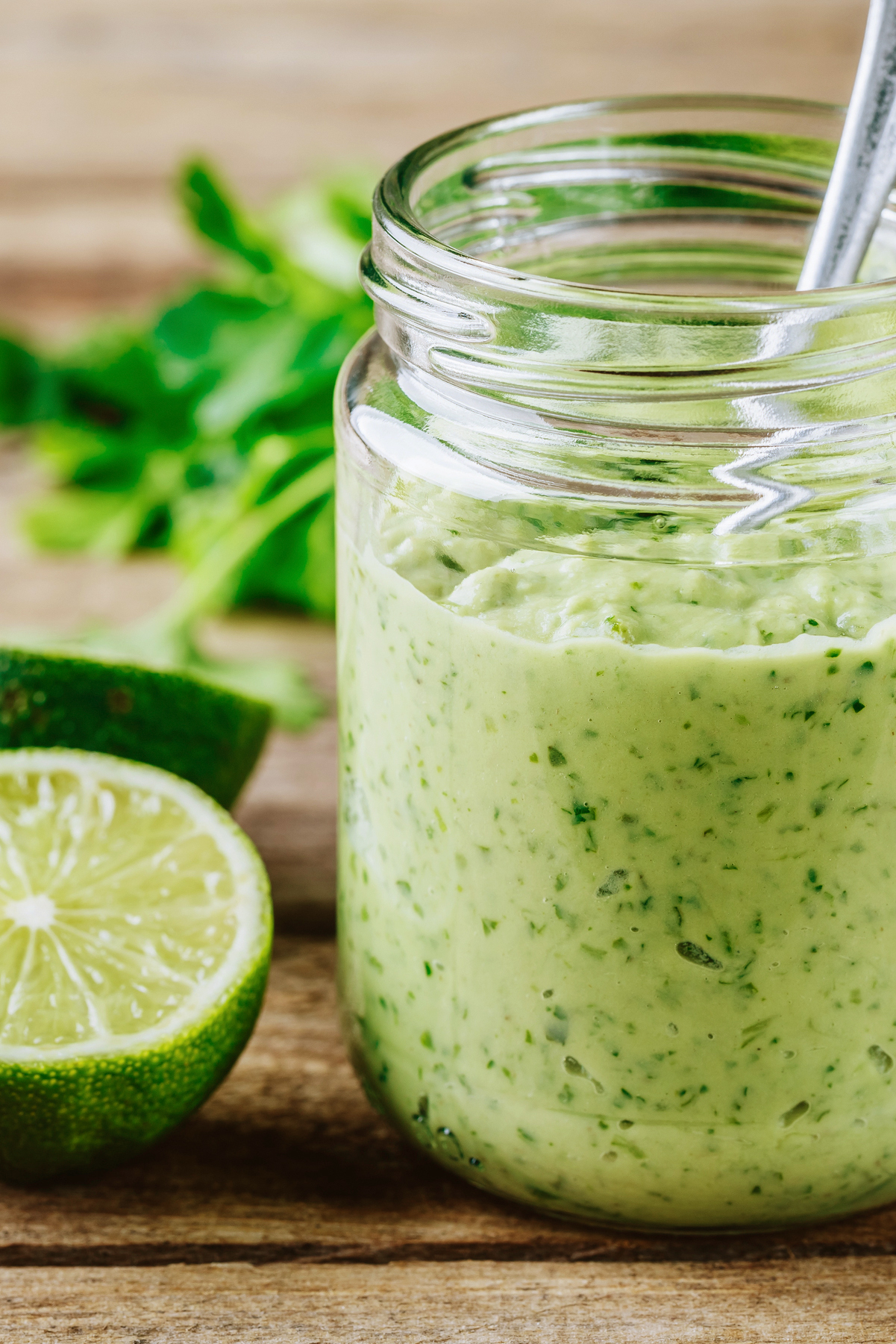 Closeup of Easy Weight Watchers Lime Avocado Sauce in a clear glass jar.