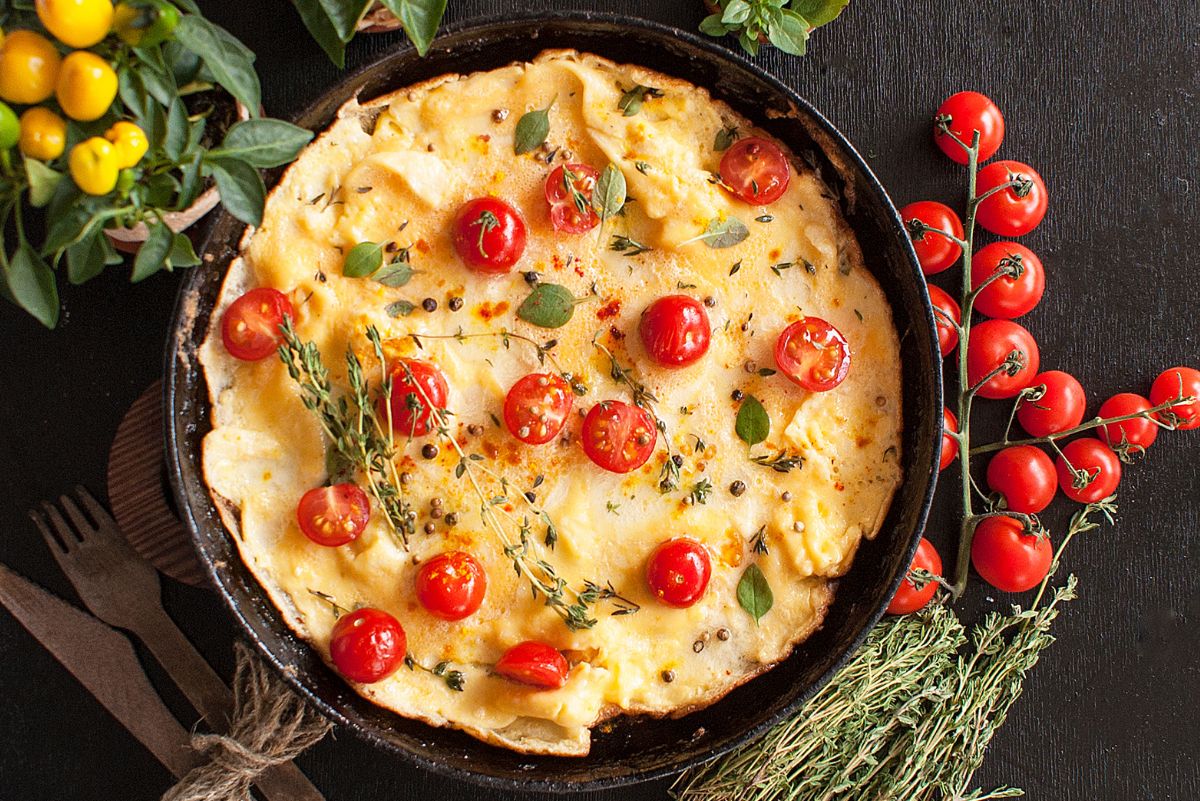 Weight Watchers Italian Omelet in a black skillet surrounded by fresh ingredients.