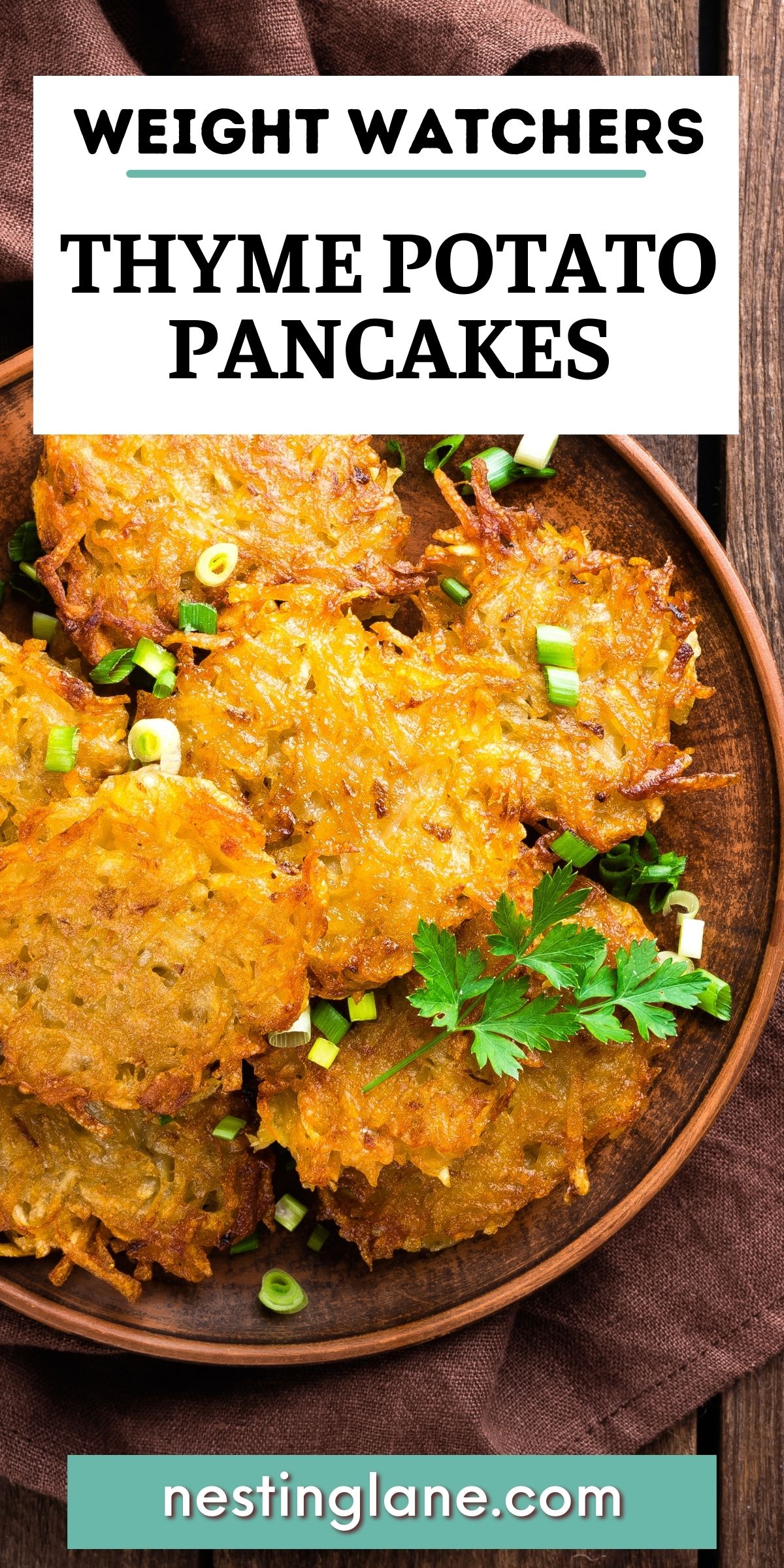 Golden brown thyme potato pancakes stacked on a rustic wooden plate, crisp shredded potato edges with chopped green onions and fresh parsley on top. Set on a dark wood table with a linen cloth. Text reads “WEIGHT WATCHERS THYME POTATO PANCAKES” and “nestinglane.com”.