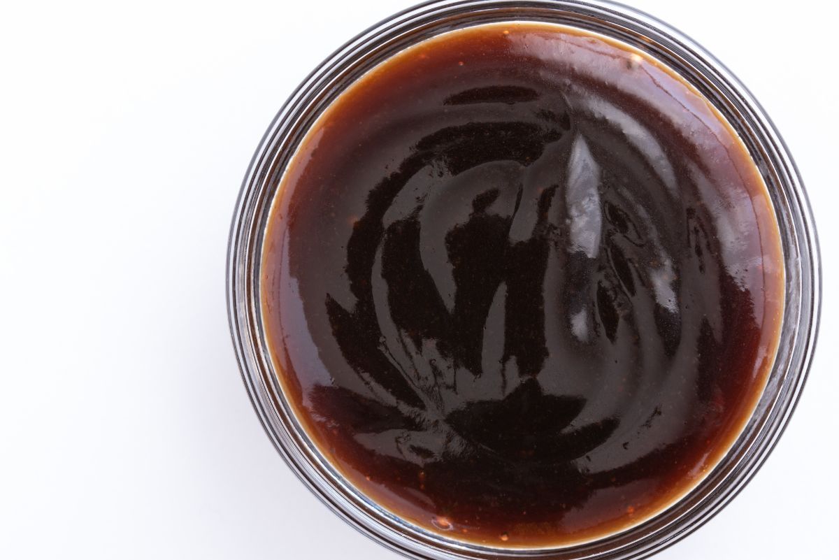 Overhead view of Weight Watchers Asian Barbecue Sauce in a clear glass bowl on a bright, white surface.