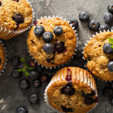 Closeup of Weight Watchers Low Fat Blueberry Muffins on a dark gray surface.