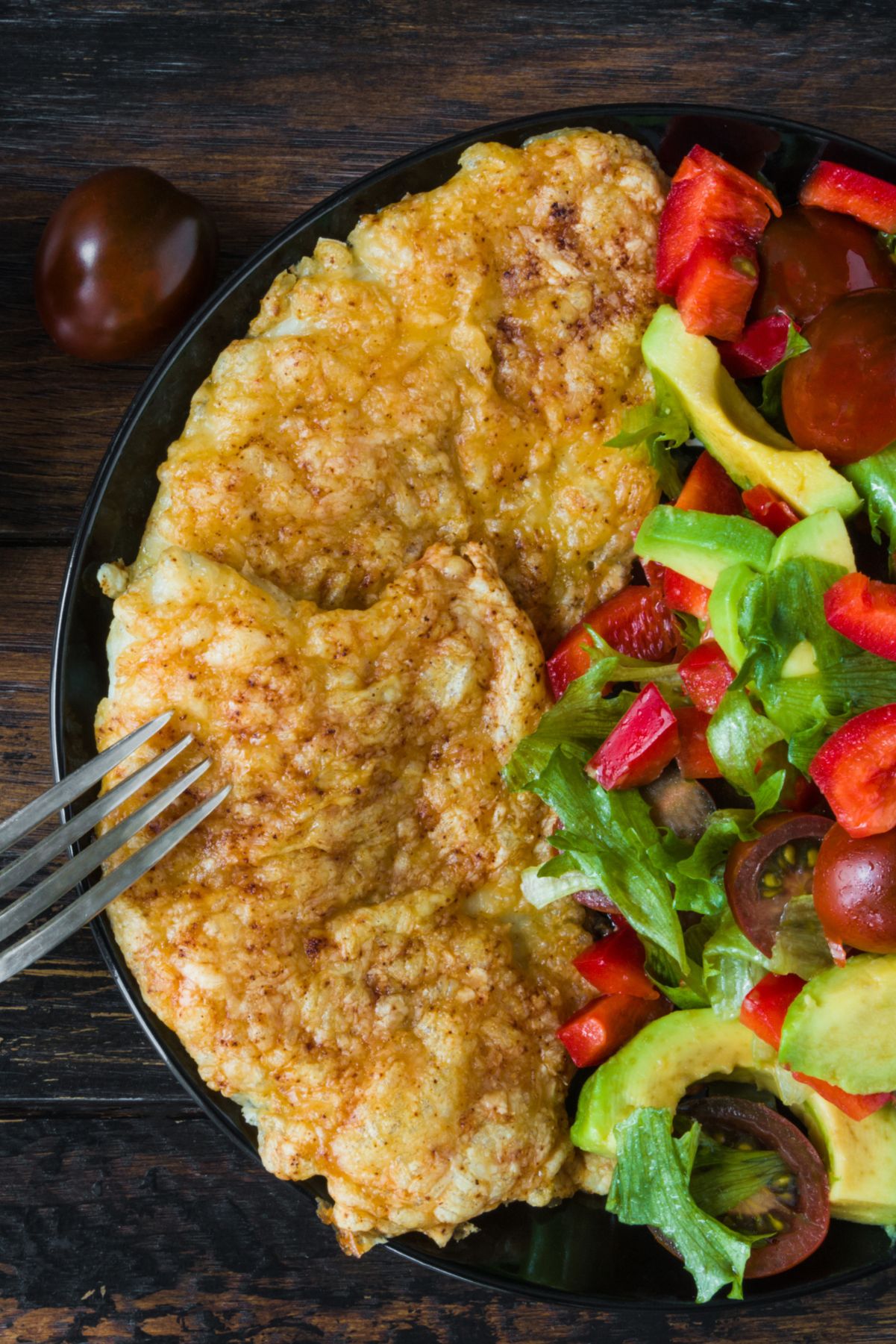 Closeup of Weight Watchers Parmesan Tilapia Fillets on a plate with a colorful salad.