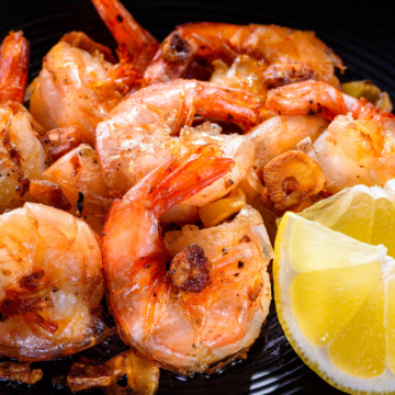 closeup of Weight Watchers Seared Garlic Shrimp on a black plate.