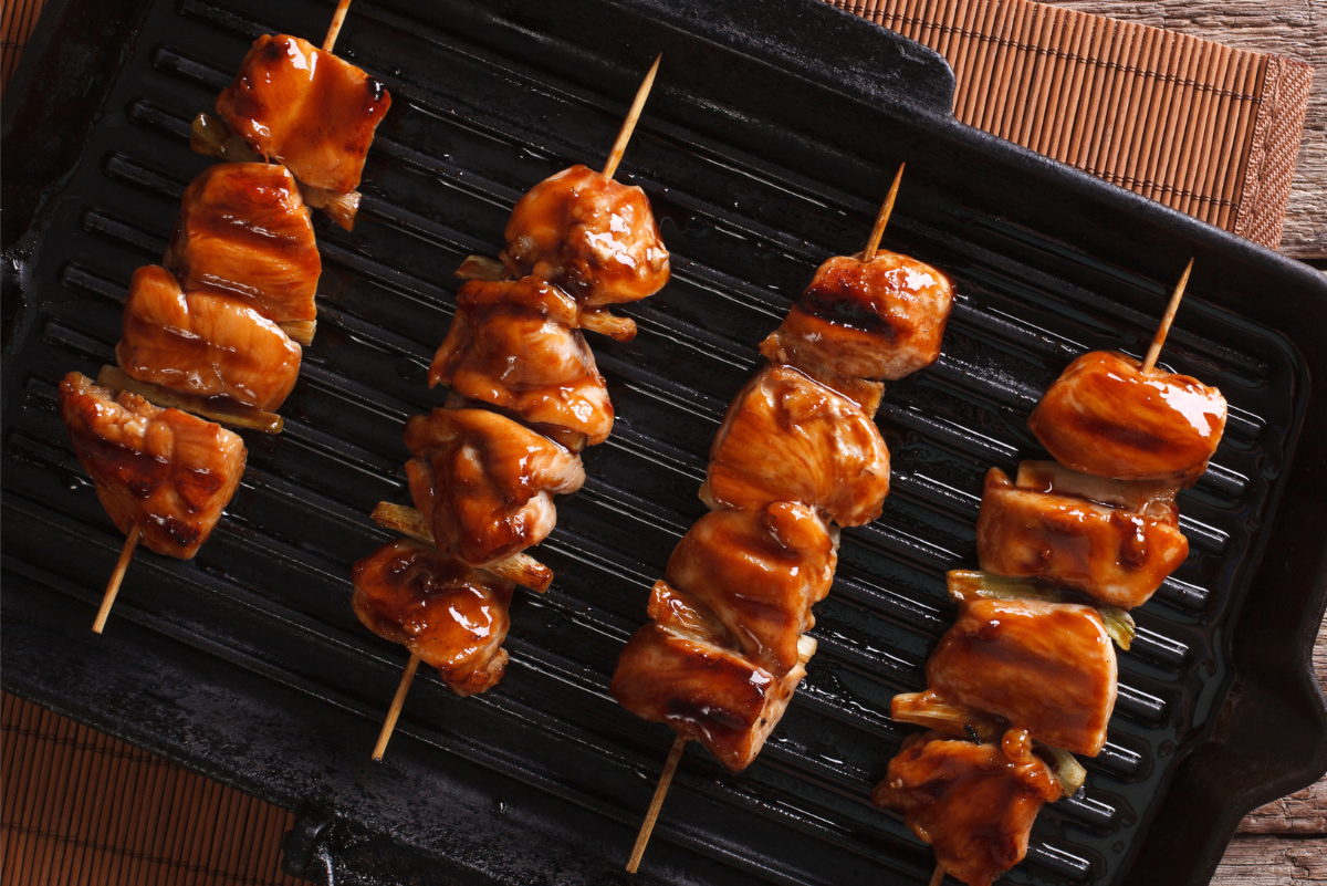 Simple Weight Watchers Chicken Yakitori on skewers, sitting on a black pan.