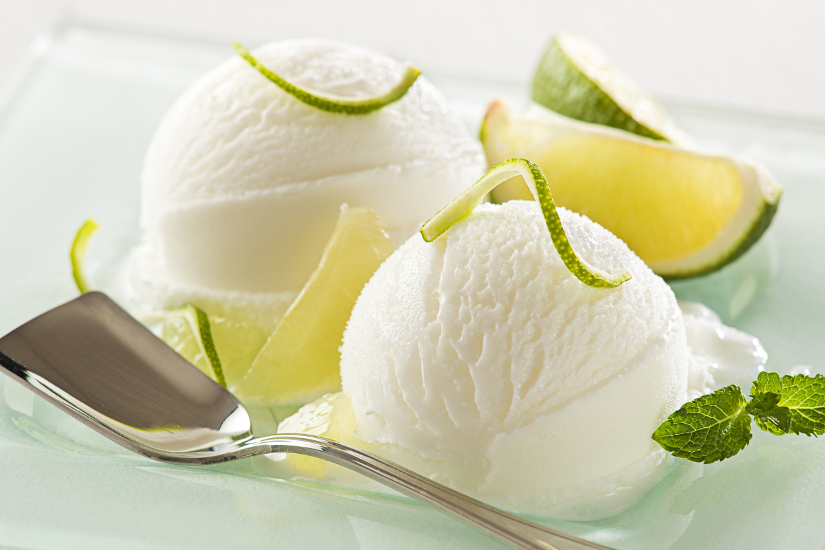 2 scoops of Homemade Key Lime Ice Cream (Weight Watchers) with sliced limes and a spoon.