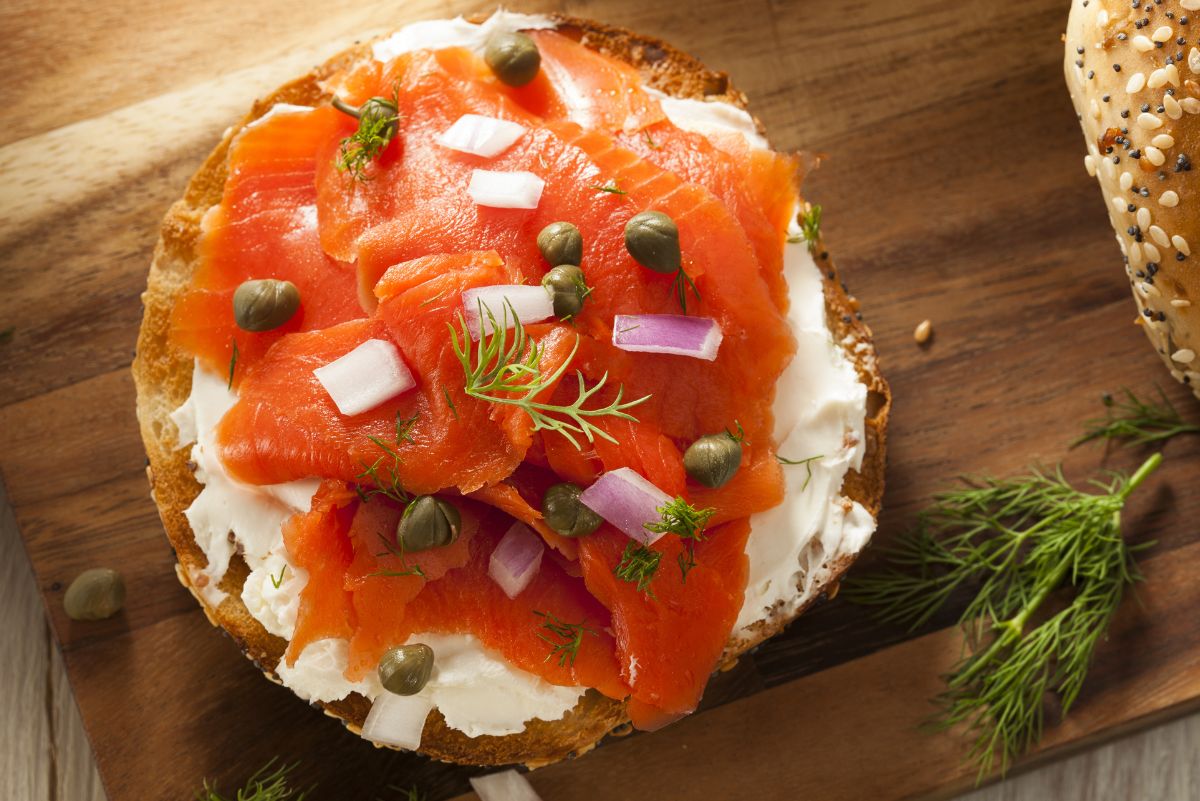 Overhead view of Weight Watchers Smoked Salmon English Muffin with Cream Cheese on a wooden surface.