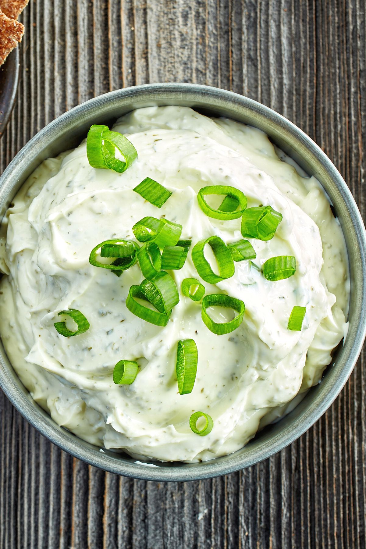 Overhead closeup view of Weight Watchers Herb Buttermilk Dip Recipe in a white bowl.