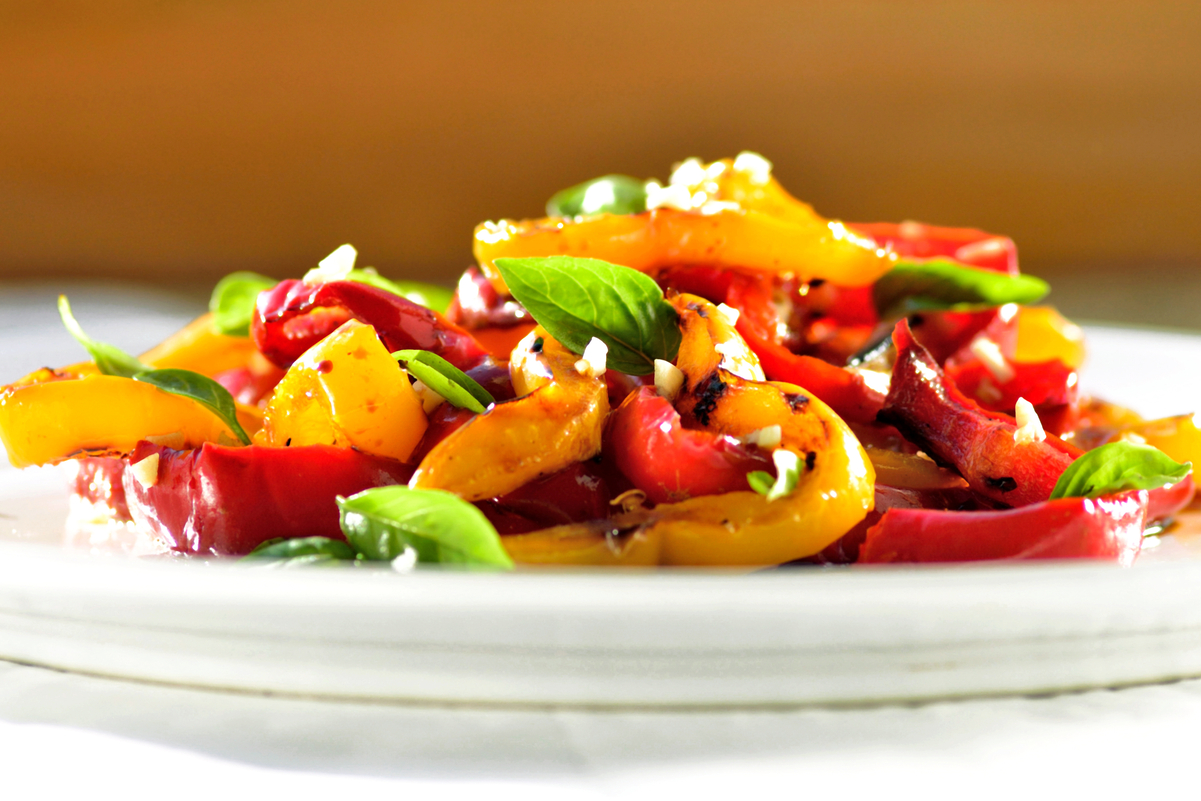 Weight Watchers Roasted Peppers and Onions on a white plate with an out of focus, orange background.