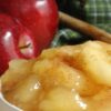 Weight Watchers Slow Cooker Baked Apples in a white bowl with fresh apples behind it.