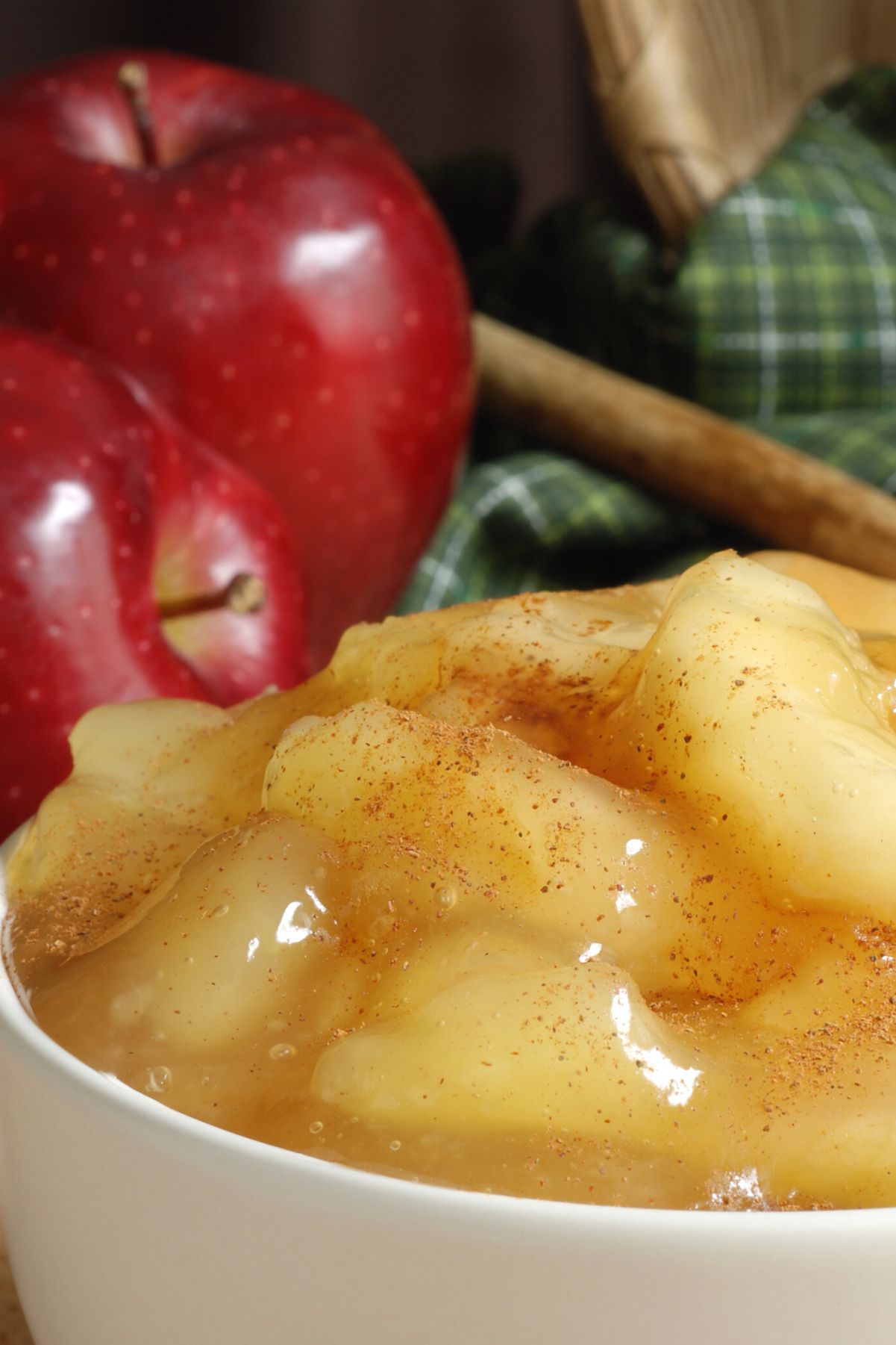 Weight Watchers Slow Cooker Baked Apples in a white bowl with fresh apples behind it.