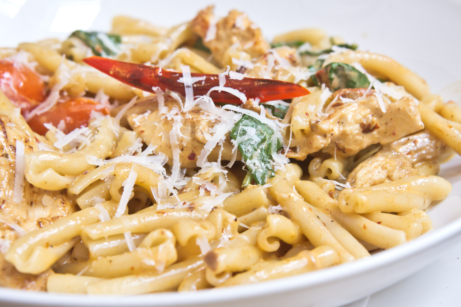 Weight Watchers Spicy Chicken Pasta on a white plate with a white background.