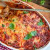 Closeup of Easy Weight Watchers Eggplant Parmigiana in a white casserole dish.