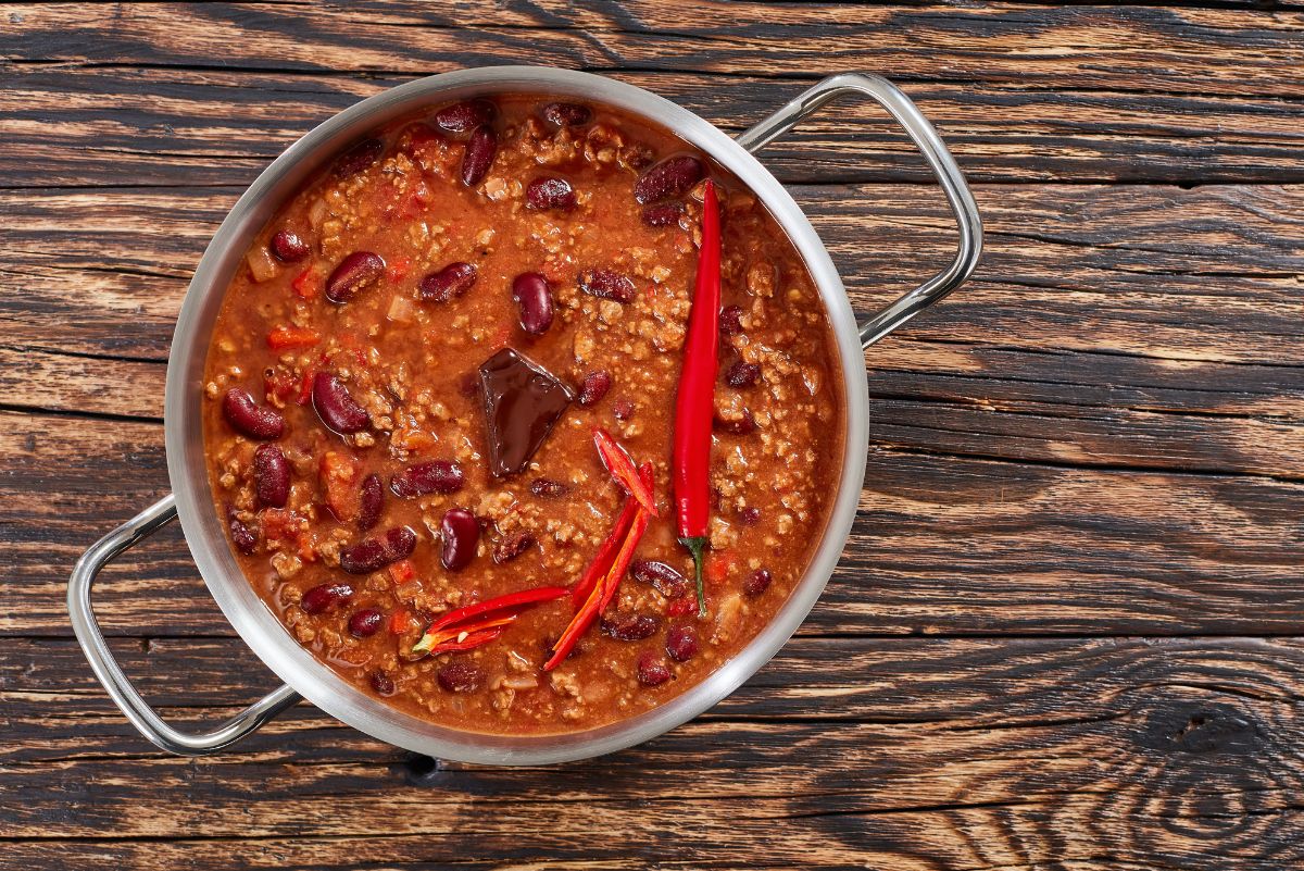 Overhead view of Weight Watchers Beef and Bean Chili in pot sitting on a rustic wooden surface.