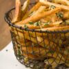 Weight Watchers Crispy Romano Cheese French Fries in a wire basket.