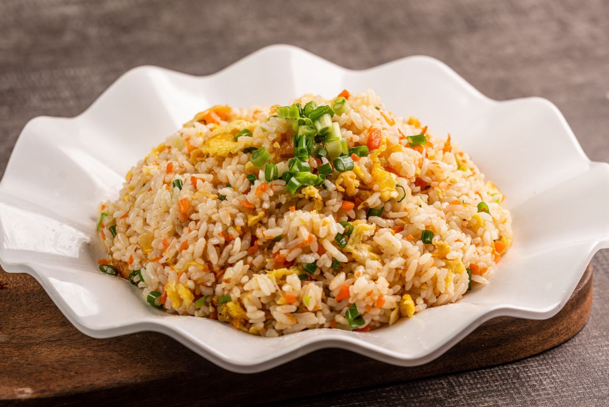 Weight Watchers Air Fryer Fried Rice in a white scalloped plate on a rustic wooden surface.