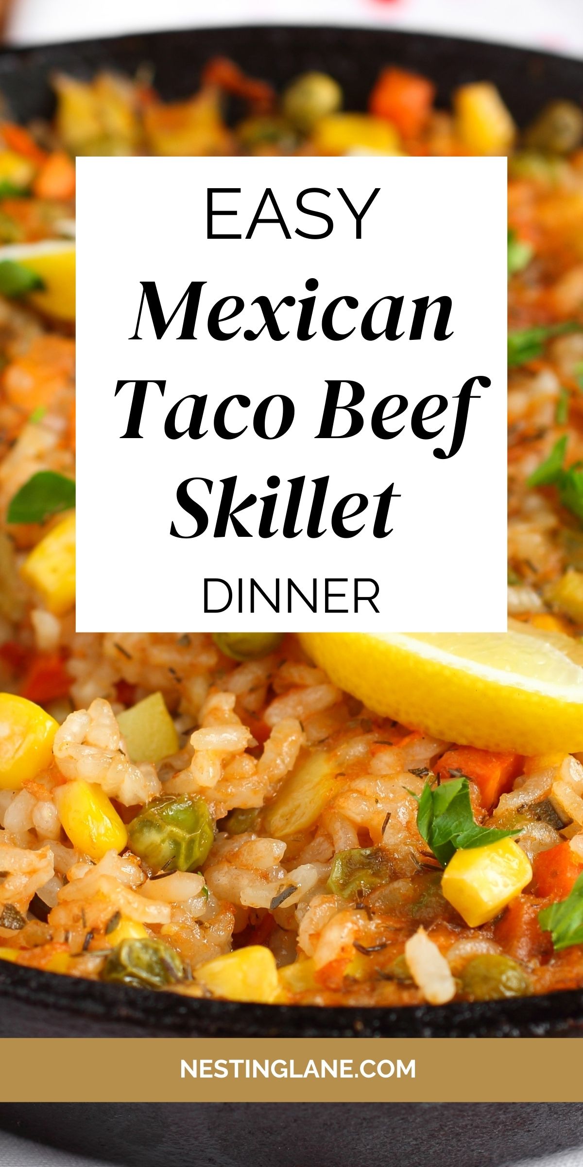 Colorful taco beef skillet dinner with rice, corn, peas, peppers, and fresh herbs cooked together in a cast iron pan, garnished with lemon wedges. Center text overlay reads “Easy Mexican Taco Beef Skillet Dinner” with nestinglane.com at the bottom.