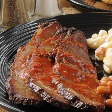 Sliced Finger-Lickin’ Slow Cooker BBQ Beef Brisket on a black dinner plate.