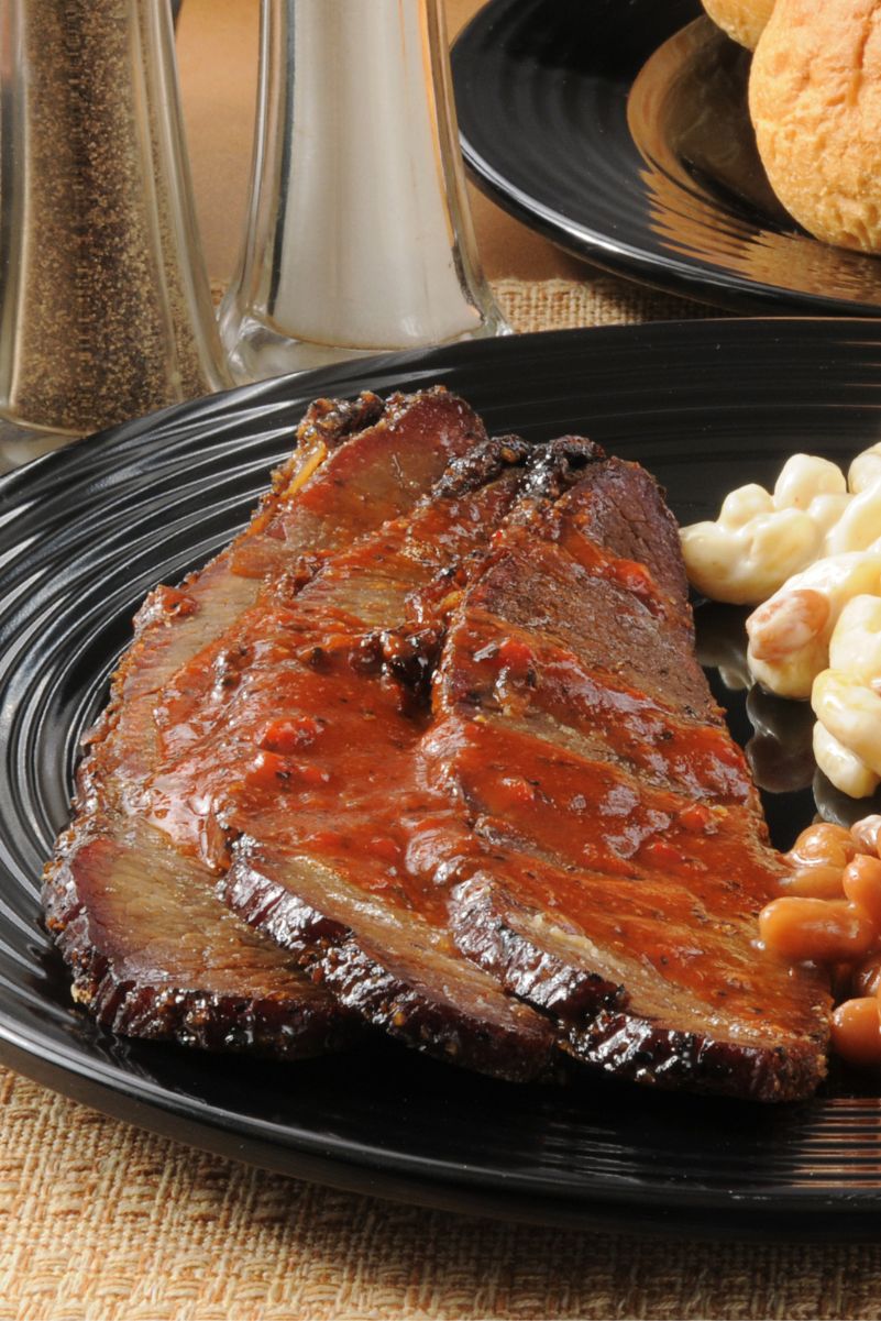 Sliced Finger-Lickin’ Slow Cooker BBQ Beef Brisket on a black dinner plate.