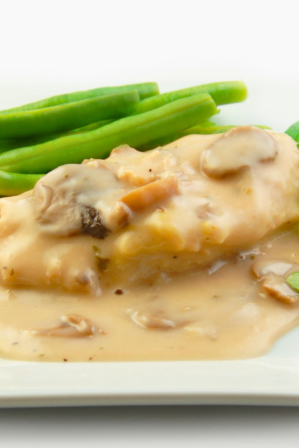 Melt in Your Mouth Slow Cooker Italian Chicken with green beans on a white plate.