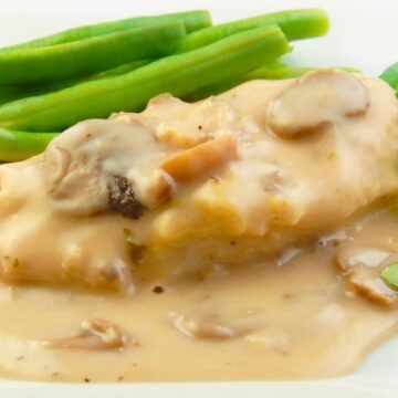 Melt in Your Mouth Slow Cooker Italian Chicken and green beans on a white plate with a bright white background.
