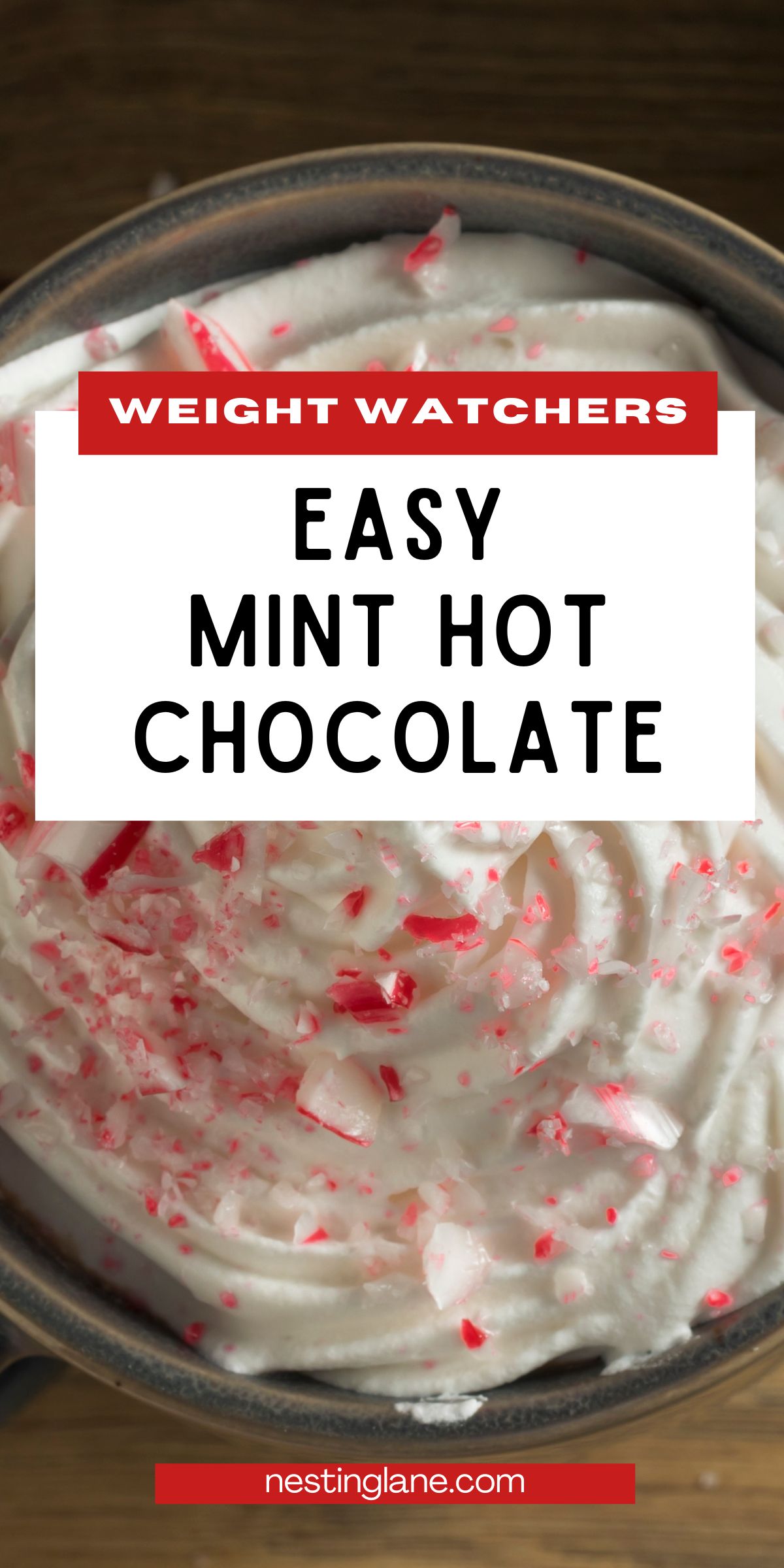 Creamy mint hot chocolate topped with whipped cream and crushed peppermint candy in a mug. Red and white candy pieces scattered on top. Overlaid text reads “WEIGHT WATCHERS EASY MINT HOT CHOCOLATE” with “nestinglane.com” at the bottom.