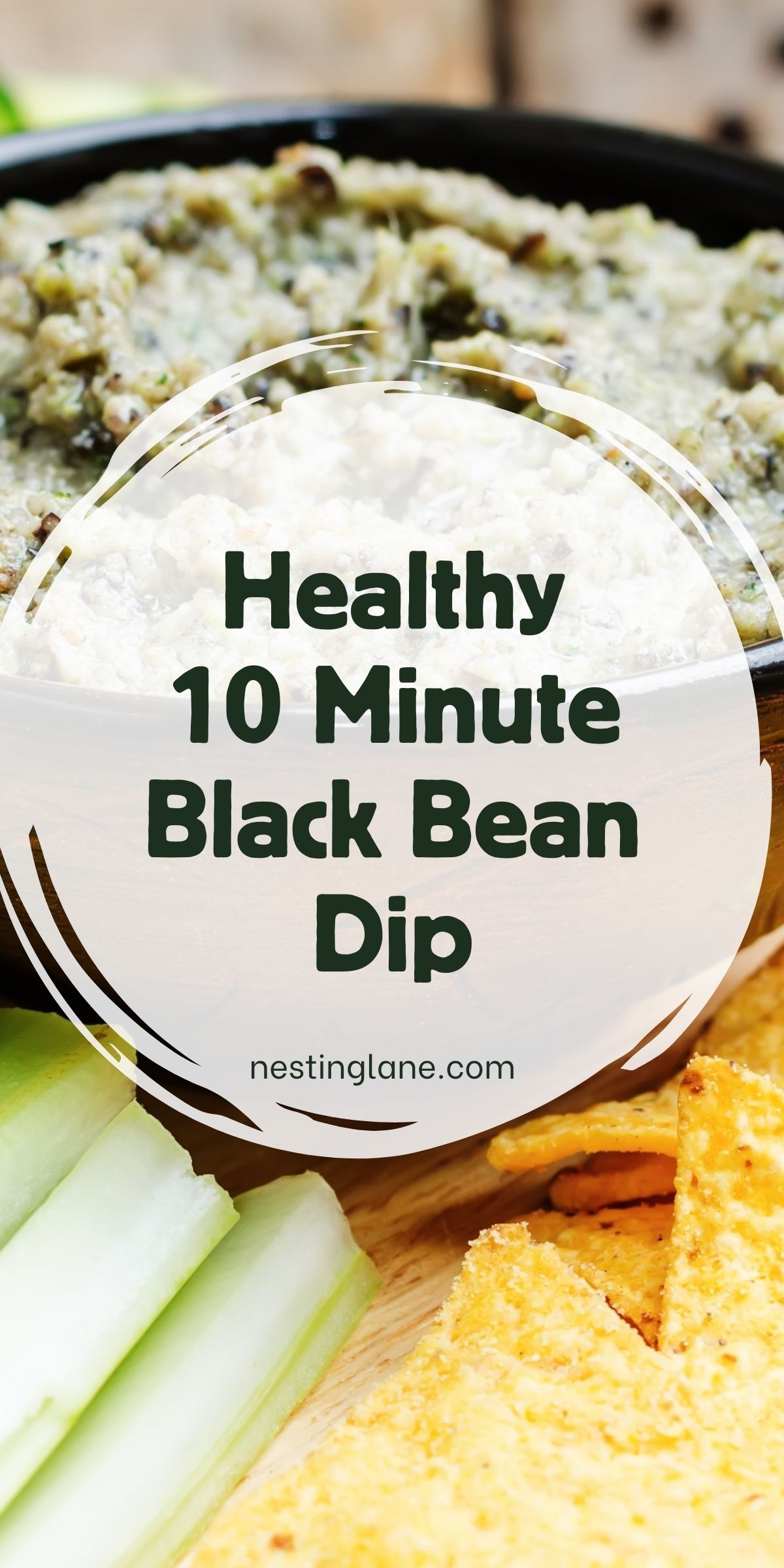 Healthy black bean dip in a black bowl, creamy and speckled with herbs, set on a wooden board with tortilla chips and celery sticks. Text overlay reads “Healthy 10 Minute Black Bean Dip” with “nestinglane.com.” Close-up food photography highlighting an easy, quick appetizer dip.