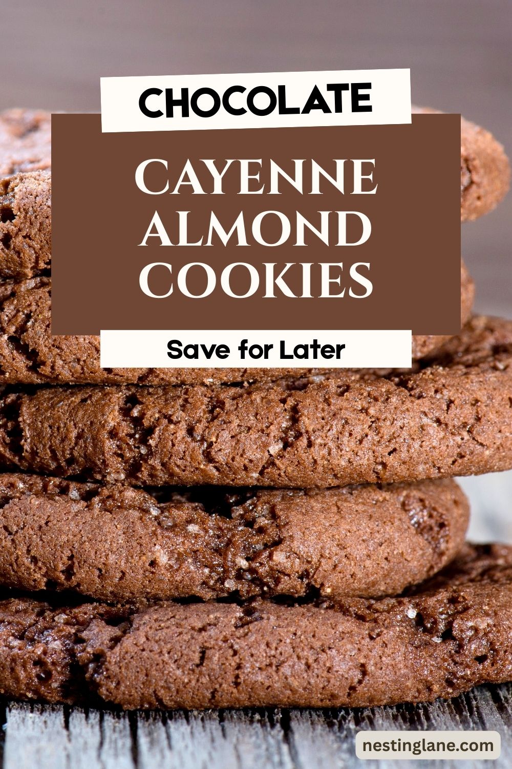 Stack of thick chocolate cookies with a slightly cracked, soft-baked texture and visible sugar crystals, set on a rustic surface. Overlaid text reads “CHOCOLATE,” “CAYENNE ALMOND COOKIES,” and “Save for Later.” Nestinglane.com appears in the corner. Rich chocolate almond cookies with a hint of cayenne spice.
