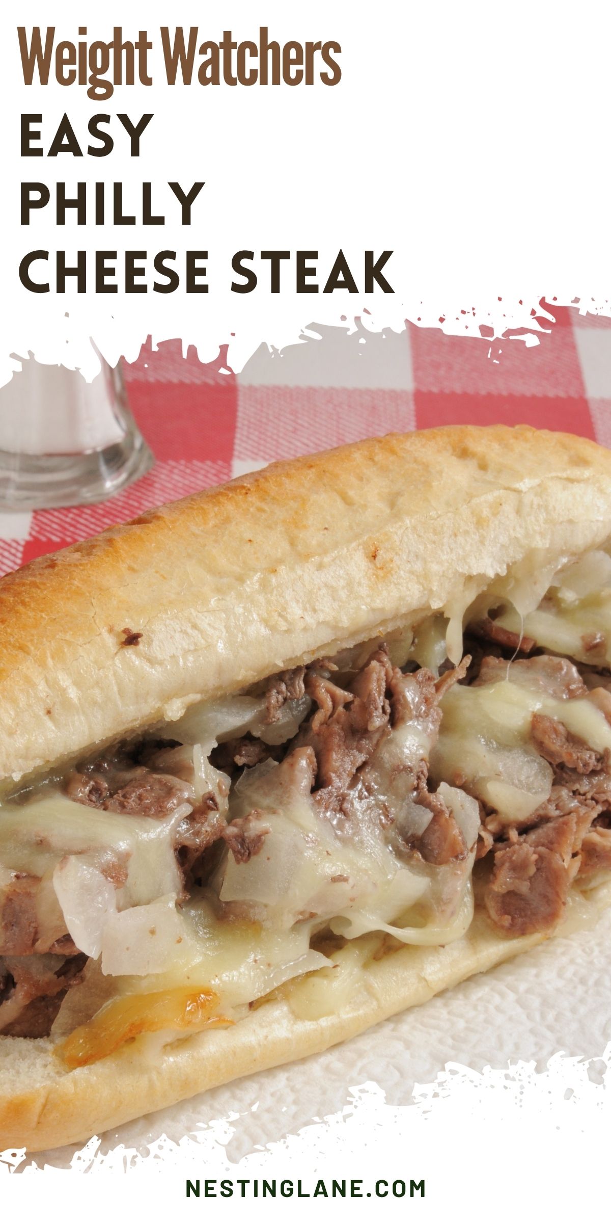 Close-up of a Philly cheesesteak sandwich on a hoagie roll, filled with thin sliced beef, melted cheese, and diced onions. Red and white checkered tablecloth in the background. Text reads “Weight Watchers EASY PHILLY CHEESE STEAK” and “NESTINGLANE.COM”.