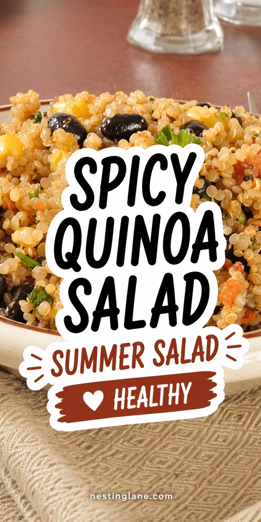 Pinterest pin for spicy quinoa salad in a bowl with quinoa, black beans, corn, diced peppers, and herbs on a tabletop. Text on image says: “SPICY QUINOA SALAD” “SUMMER SALAD” “HEALTHY” and “nestinglane.com”.