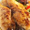 Grilled chicken breasts with sweet chili glaze served over fresh greens, red bell pepper, and leafy salad on a white plate.