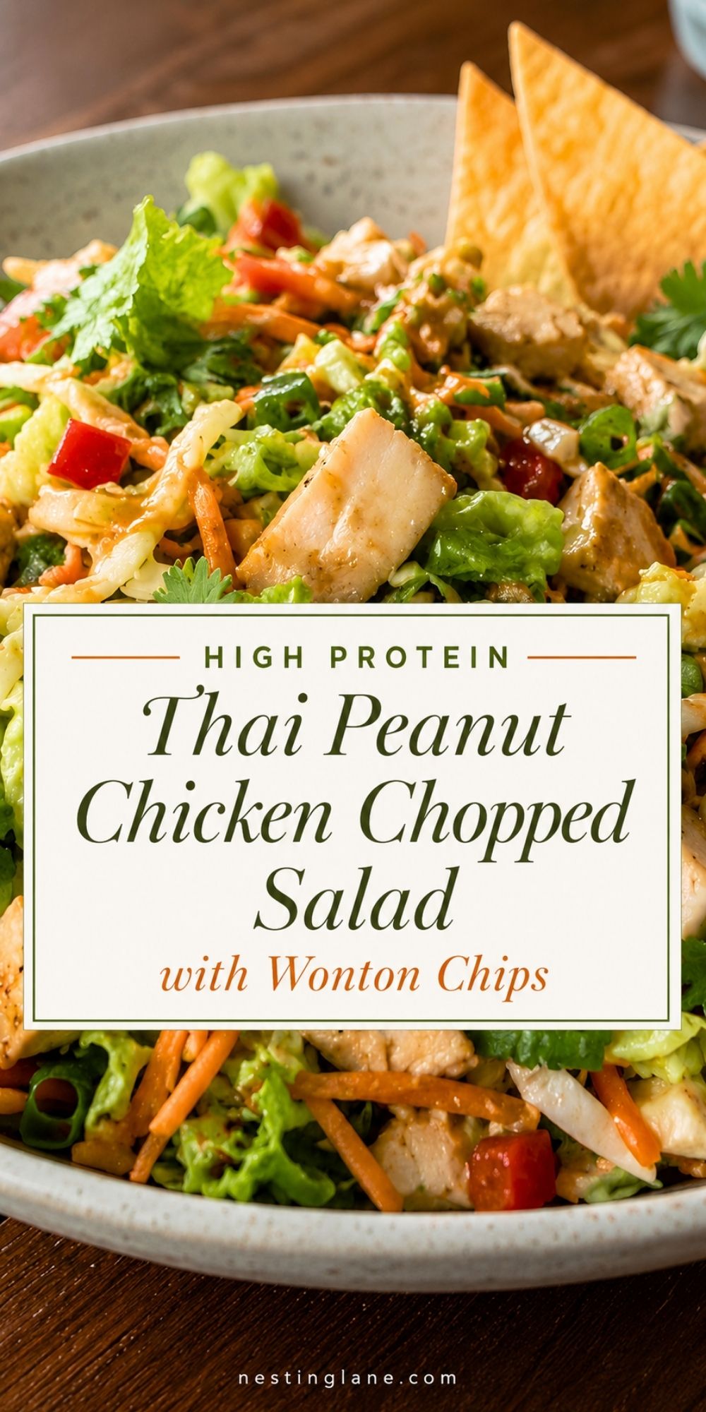 High protein Thai peanut chicken chopped salad with lettuce, chicken, carrots, red bell pepper, cilantro, creamy peanut dressing, and crispy wonton chips. Text reads: “High Protein Thai Peanut Chicken Chopped Salad with Wonton Chips” and “nestinglane.com.”