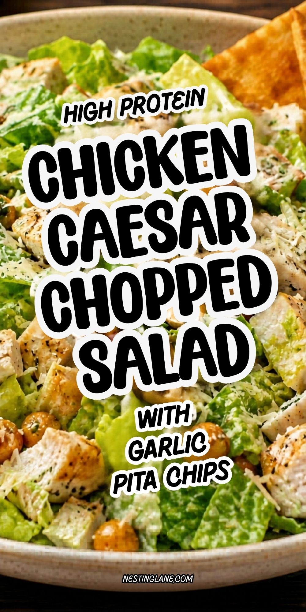 High protein chicken Caesar chopped salad with romaine lettuce, grilled chicken, Parmesan, chickpeas, and garlic pita chips. Text reads “High Protein Chicken Caesar Chopped Salad with Garlic Pita Chips” and “nestinglane.com kitcheninformant.com.”