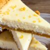 Slices of light lemon pie stacked on a plate with creamy lemon filling, graham cracker crust, and fresh lemon zest sprinkled on top.