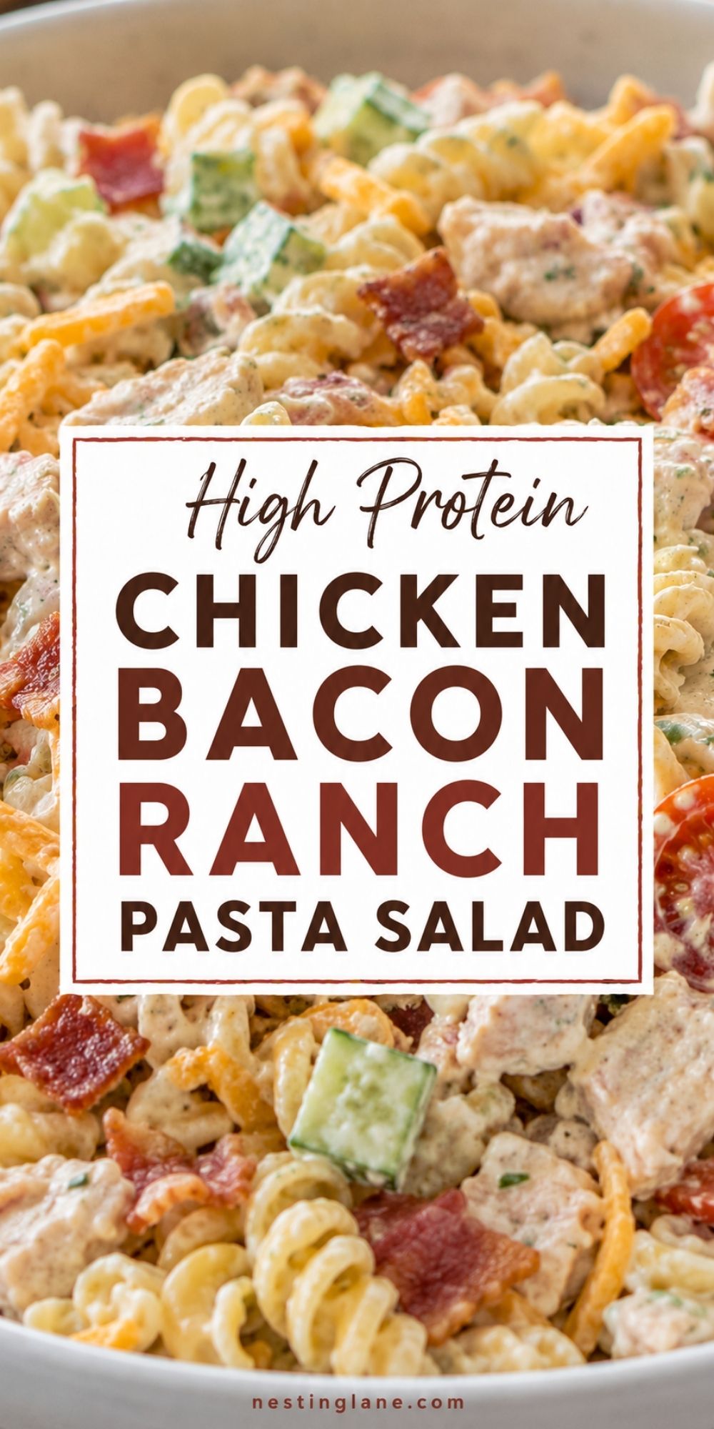 Creamy chicken bacon ranch pasta salad with rotini, cheddar, cucumber, tomato, bacon, and chicken. Text reads “High Protein Chicken Bacon Ranch Pasta Salad” with “nestinglane.com” at the bottom.