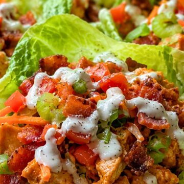 Crispy Buffalo chicken BLT lettuce wraps with chopped chicken, bacon, tomato, celery, carrots, green onions, and creamy ranch dressing piled into fresh lettuce cups.