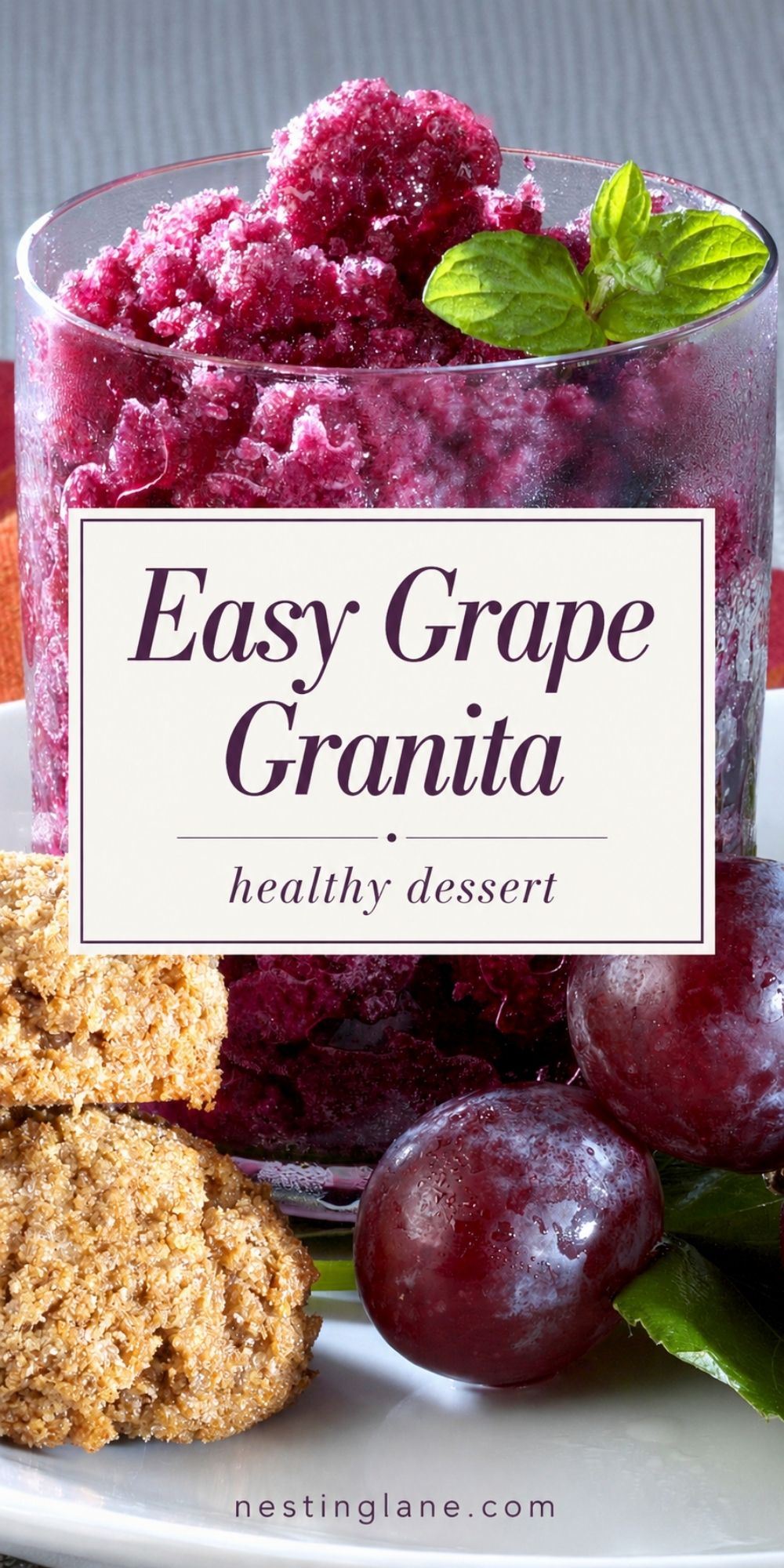 Grape granita in a clear glass with icy purple crystals, fresh mint, red grapes, and oat cookies on a white plate. Overlay text reads “Easy Grape Granita” and “healthy dessert,” with “nestinglane.com” at the bottom.