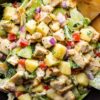 Hawaiian chicken chopped salad with grilled chicken, pineapple, cucumbers, lettuce, red bell peppers, red onion, and crispy chips.