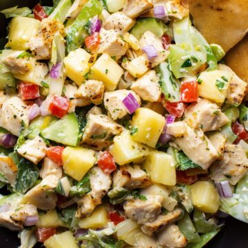Hawaiian chicken chopped salad with grilled chicken, pineapple, cucumbers, lettuce, red bell peppers, red onion, and crispy chips.