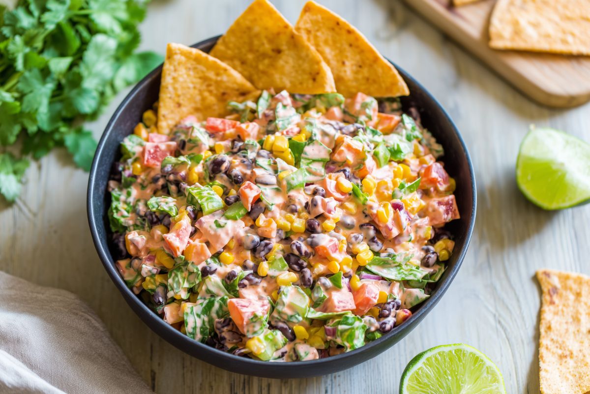 Southwest chopped salad with black beans, corn, tomatoes, bell peppers, red onion, lettuce, creamy dressing, and tortilla chips.