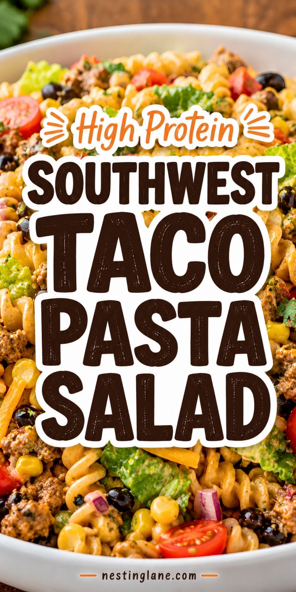 High protein Southwest taco pasta salad with rotini, ground beef, corn, black beans, tomatoes, lettuce, cheese, and creamy taco dressing. Overlay text reads “High Protein Southwest Taco Pasta Salad” with “nestinglane.com” at the bottom.