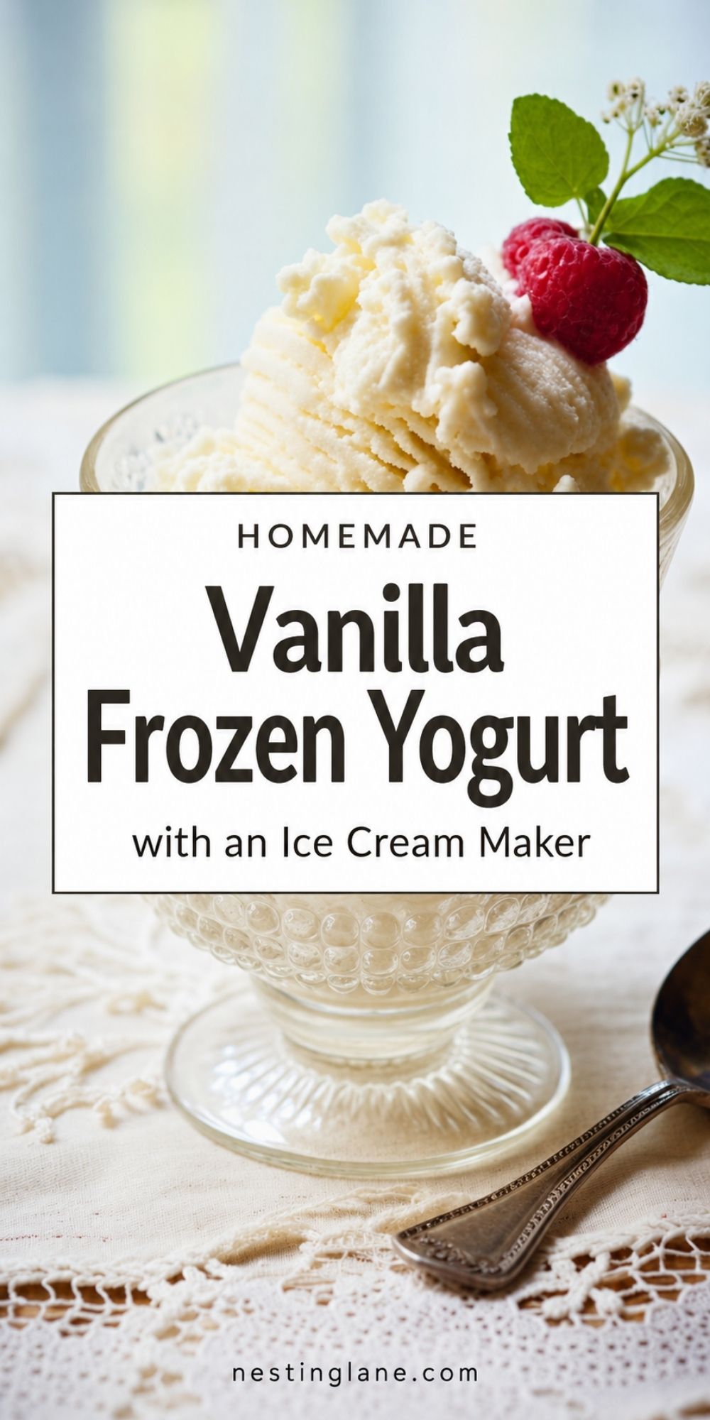Vanilla frozen yogurt in a glass dessert cup topped with a raspberry and mint, with a spoon on a lace tablecloth. Text reads “Homemade Vanilla Frozen Yogurt with an Ice Cream Maker” and “nestinglane.com.”