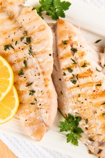 Grilled Lemon Herb White Fish Fillets on a white background.