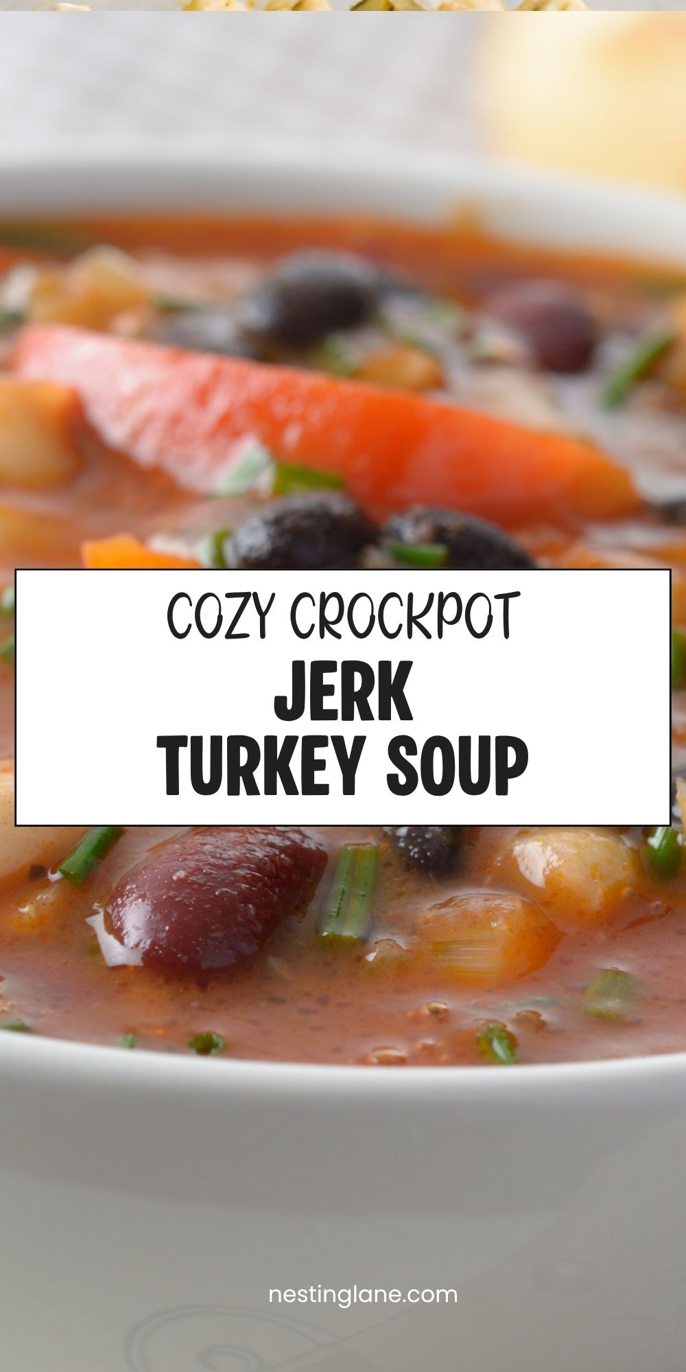 Crockpot jerk turkey soup with beans, carrots, vegetables, and green onions in a red broth. Text reads “Cozy Crockpot Jerk Turkey Soup” and “nestinglane.com.”