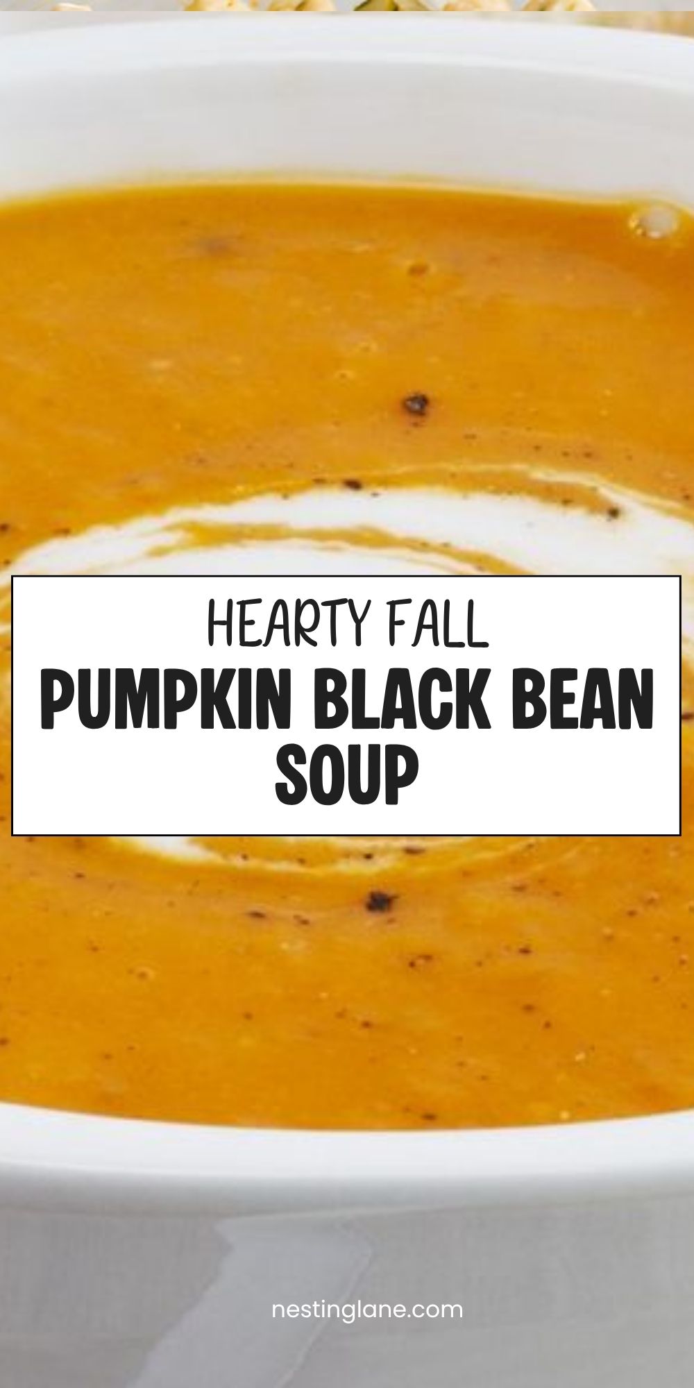 Close-up of creamy pumpkin black bean soup with a white cream swirl in a white bowl. Text reads “Hearty Fall Pumpkin Black Bean Soup” and “nestinglane.com.”