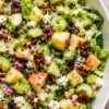Close-up apple pecan salad with chopped romaine, red apples, cucumber, celery, dried cranberries, feta cheese, red onion, and toasted pecans coated in creamy apple cider dressing.