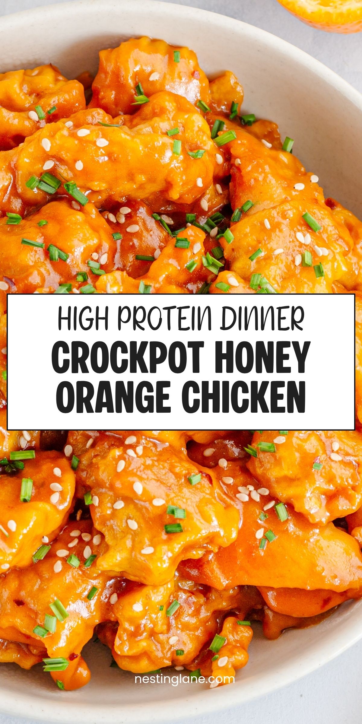 Crockpot honey orange chicken coated in a glossy orange sauce and topped with sesame seeds and chopped chives. Text reads: “High Protein Dinner Crockpot Honey Orange Chicken” and “nestinglane.com.”