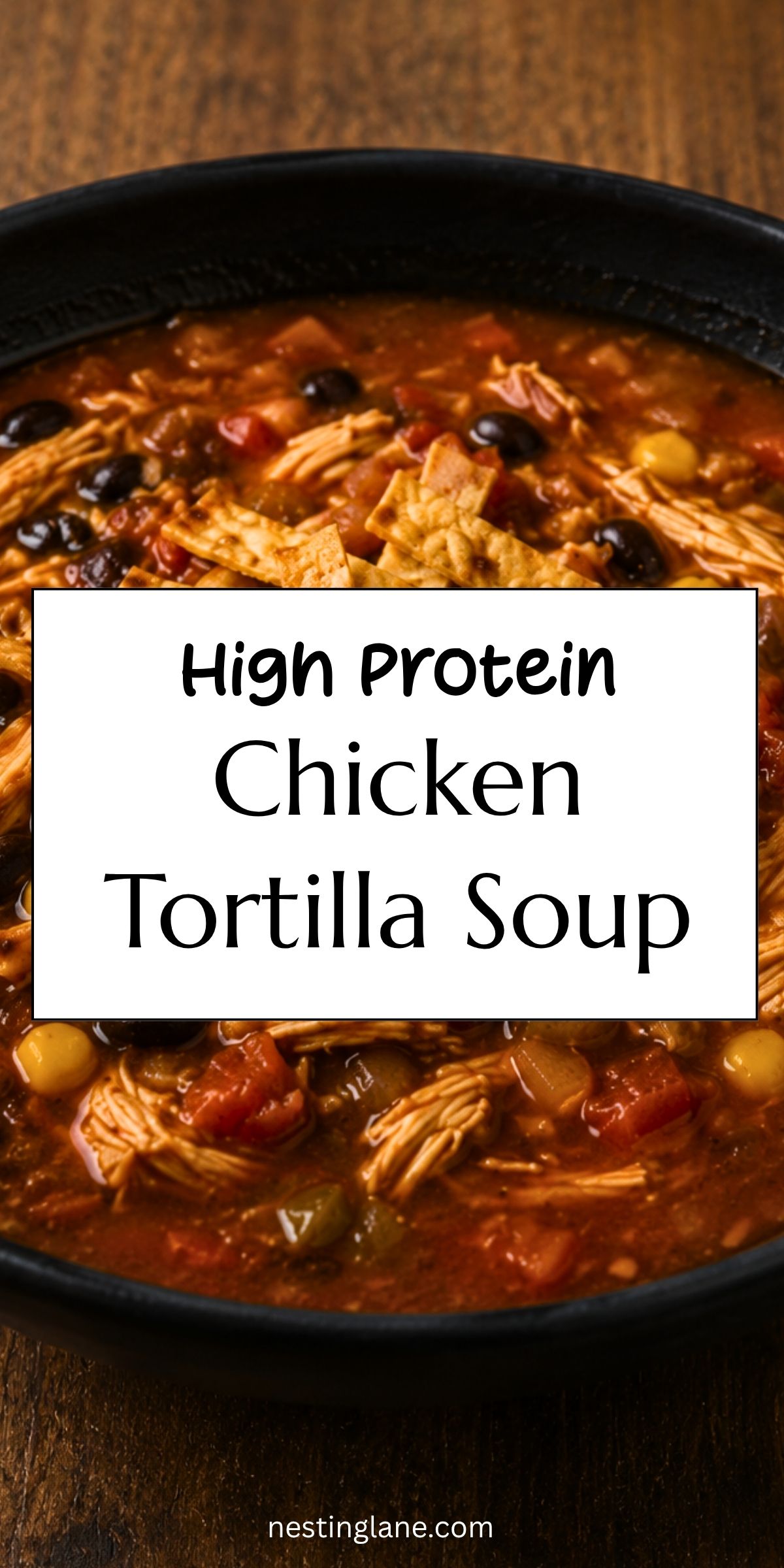 Close-up of hearty chicken tortilla soup in a black bowl with shredded chicken, black beans, corn, tomatoes, peppers, and tortilla strips. Text reads “High Protein Chicken Tortilla Soup” and “nestinglane.com.”