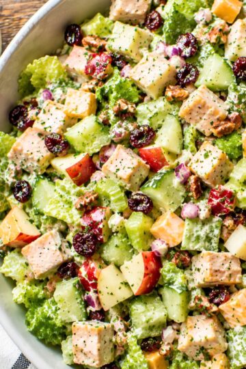 Maple Dijon Chicken Chopped Salad with chicken breast, romaine, crisp apple, cucumber, celery, cheddar cheese, dried cranberries, pecans, and red onion coated in a creamy maple Dijon dressing.
